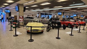 uczniowie ZSS zwiedzają wystawę ikony motoryzacji, w tle samochody z wystawy