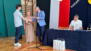 najlepszy uczeń w ZSS odbiera nagrodę z rąk wychowawczyni i Dyrektora